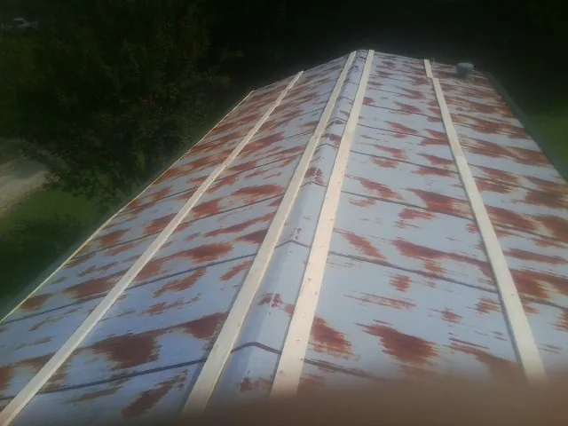 Rusted metal roof panels with new wood purlins before replacement — Storm Damage Roof Repair in Keystone Heights by Roofing Brothers