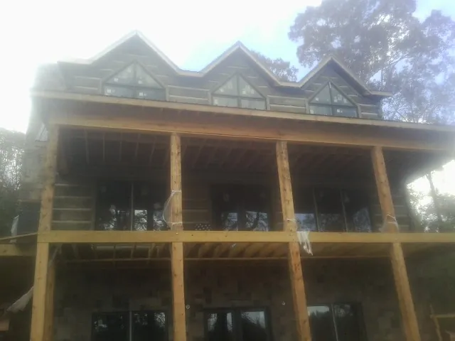 Dormers and porch framing on a large log home under construction — Roof Coating work by our crew in Keystone Heights