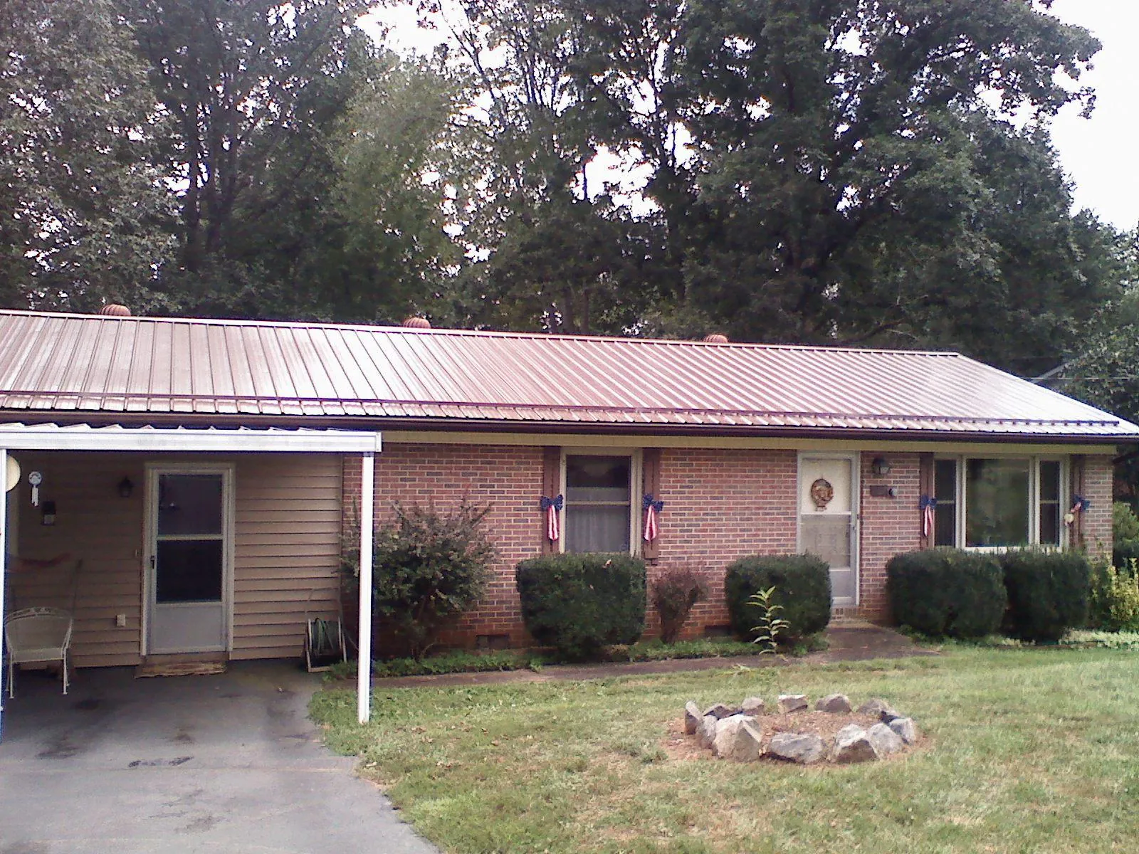Bronze metal roof and carport on a brick ranch home — Roof Repair work by our crew in Keystone Heights